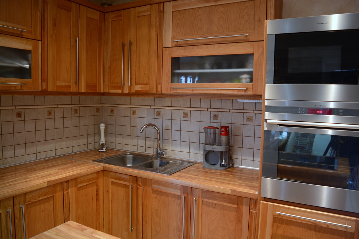 Tömör cseresznyefa konyha szigettel és beépített konyhai gépekkel.