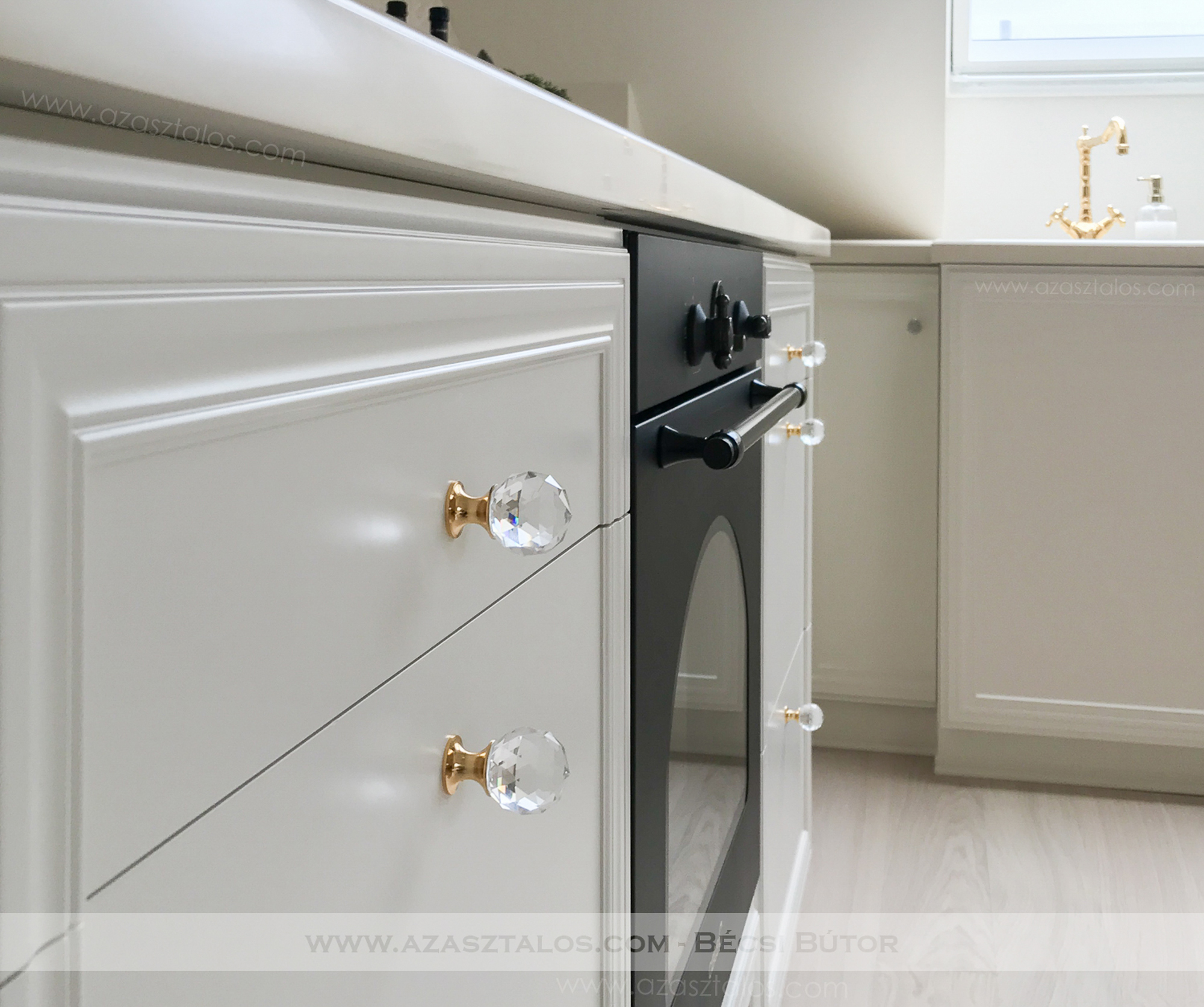 Tetőtéri, luxus konyhabútor. Csontszínűre festve, Swarovski, aranyozott fogantyúkkal, Corian munkapulttal. Teljesen egyedi igények alapján.